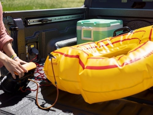 2024 Ford Maverick view of man using outlets in bed of truck to blow up a raft