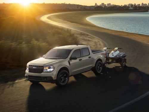2024 Ford Maverick towing two jet skis on a road